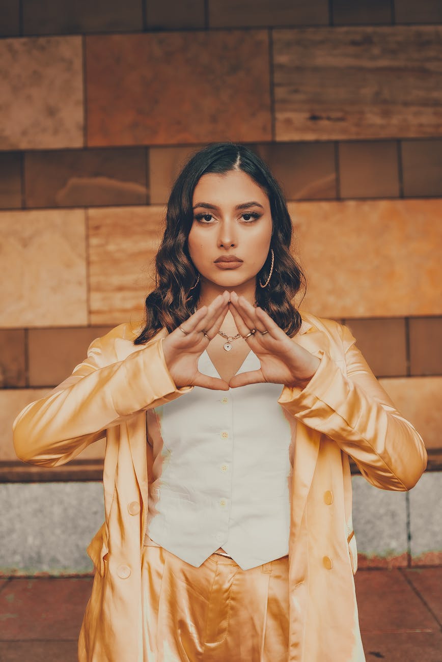 emotionless model showing illuminati triangle gesture