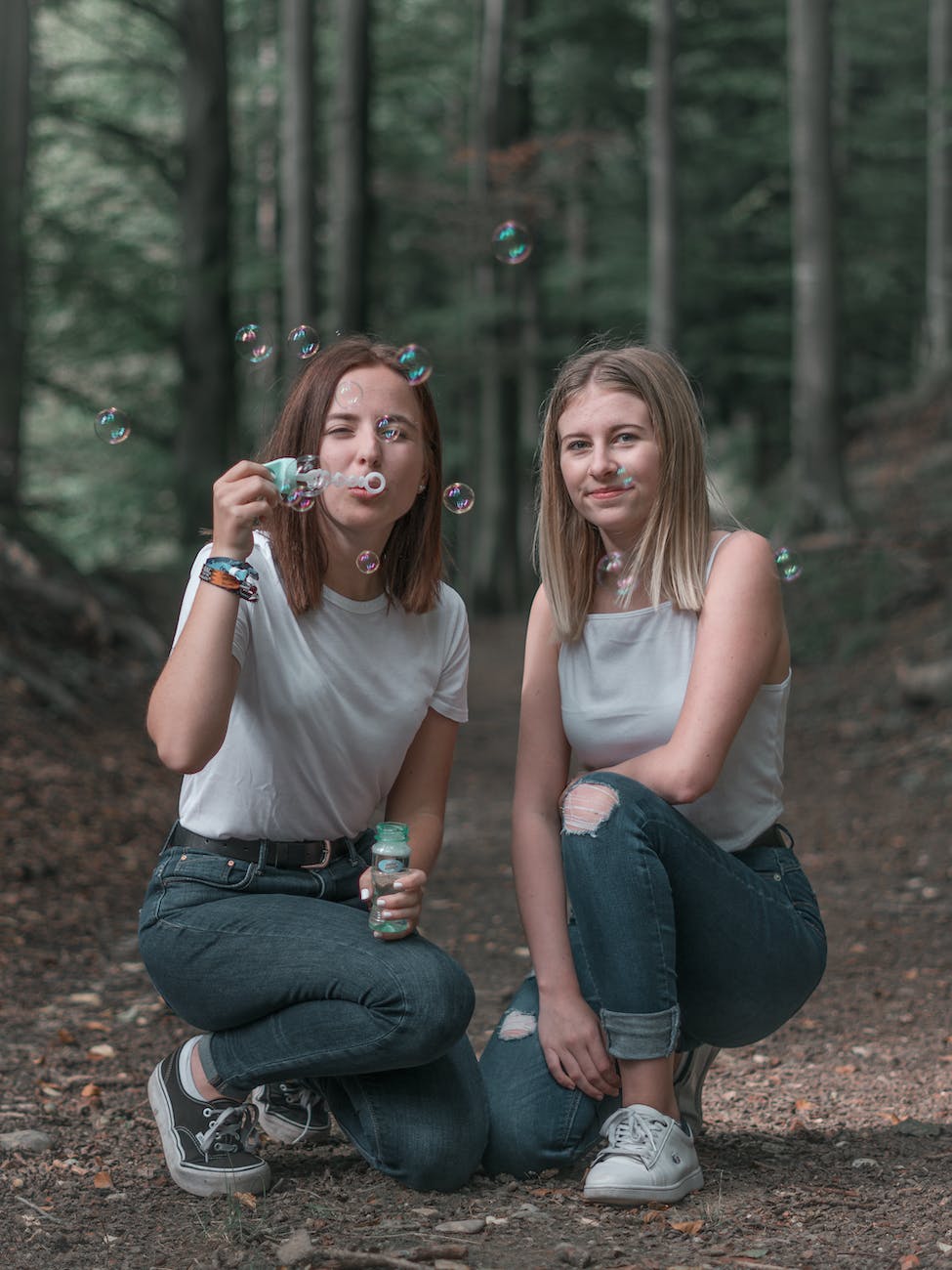 photo of women kneeling near bubbles