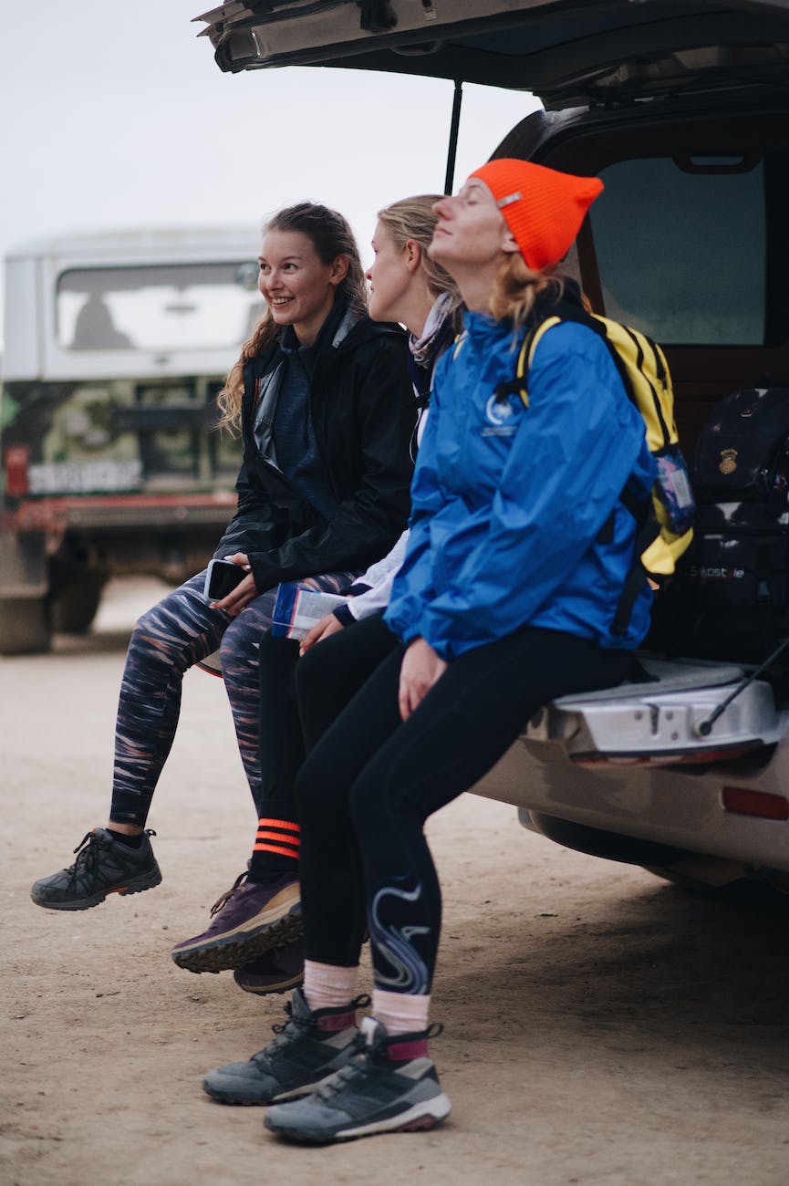 women resting on a tailgate of the van