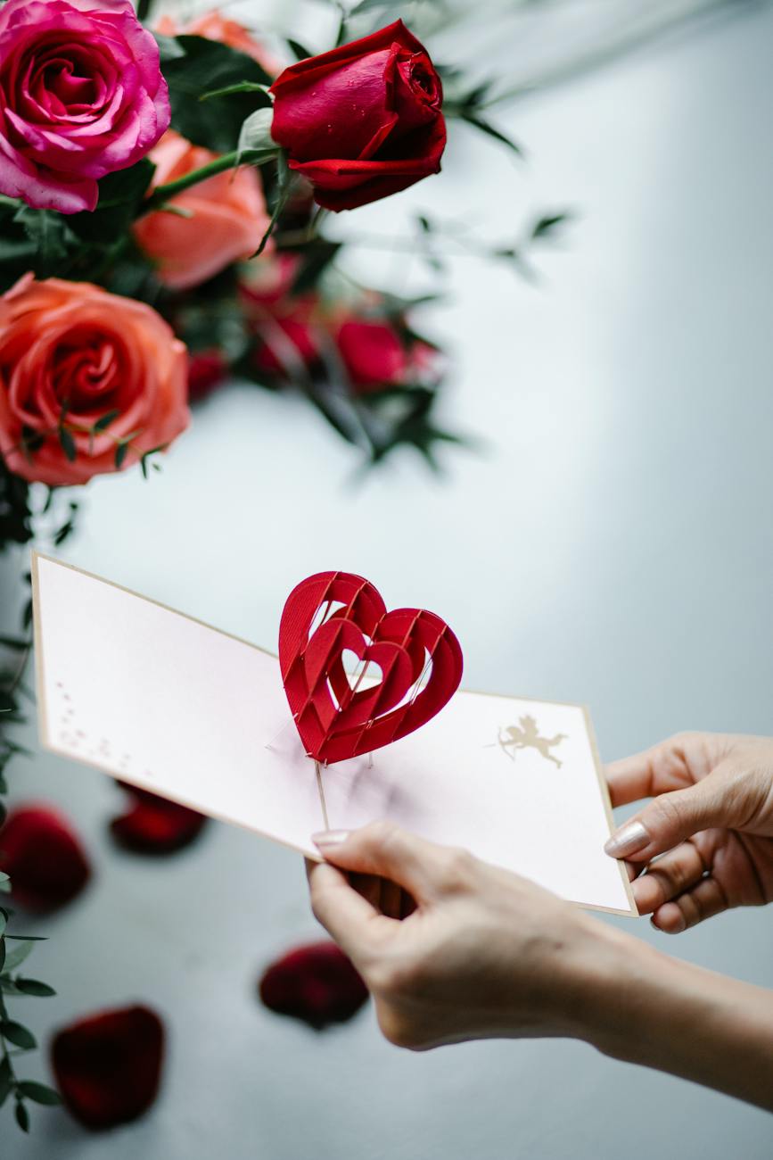 crop woman showing pop up gift card with decorative heart